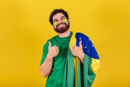 Foto de Hombre caucásico con barba, brasileño, fanático del fútbol de Brasil, pulgar hacia arriba, positivo, como, aprobación. - Imagen libre de derechos