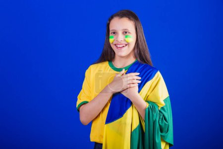 Téléchargez les photos : Jeune fille, fan de football du Brésil. habillé en drapeau, chantant l'hymne national. Remerciements. - en image libre de droit