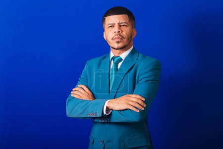 Photo for Brazilian black man, dressed in a suit and blue tie. business man. with crossed arms, serious face. - Royalty Free Image