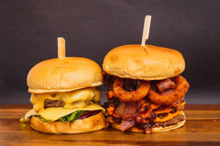Foto de Dos hamburguesas artesanales, hechas con carne de res, queso y tocino. Anillos de cebolla frita. - Imagen libre de derechos