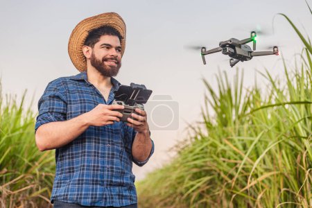 Photo for Young agricultural worker, agronomist, using drone for crop analysis, computerization, planting automation. Drone in agricultural use. - Royalty Free Image