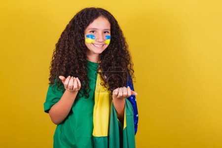 Photo for Brazilian, Caucasian, football fan girl, saying come, come, here, inviting with hands, calling with hands. - Royalty Free Image