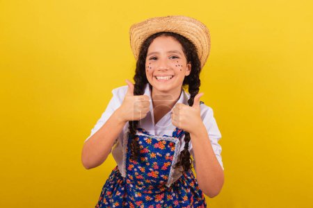 Photo for Girl wearing typical clothes for Festa Junina. Thumb up, approval, yes, positive. For the Festival do Arraia - Royalty Free Image