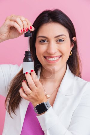 Foto de Esteticista médica, con botellas de vitamina, suplementación. en un frasco de gotero. - Imagen libre de derechos