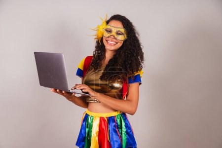 Téléchargez les photos : Belle femme brésilienne noire, portant des vêtements de carnaval, tenant un carnet, programmation, web - en image libre de droit