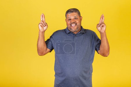 Foto de Hombre negro brasileño, adulto sonriendo, dedos cruzados, deseando, signo de suerte. - Imagen libre de derechos
