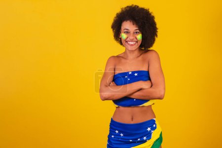 Foto de Joven mujer negra aficionada al fútbol brasileño. brazos cruzados - Imagen libre de derechos