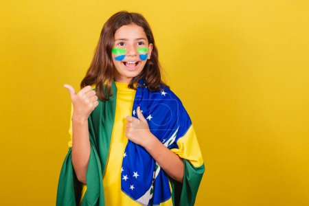 Photo for Brazilian, caucasian child, soccer fan, thumb up. approving, approval, affirmative. World Cup. Olympics. - Royalty Free Image