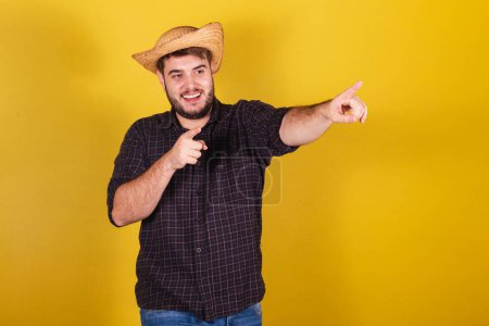 Photo for Man wearing typical clothes for Festa Junina. Feast of Arrai de So Joo. pointing towards the orizon - Royalty Free Image