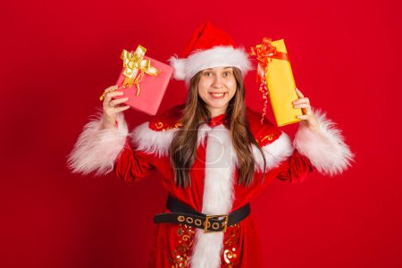 Foto de Caucásica, brasileña vestida de Navidad, Santa Claus. sosteniendo dos regalos. - Imagen libre de derechos