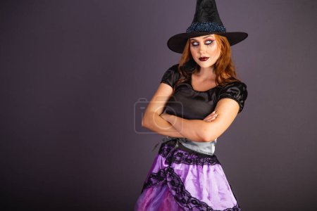 Foto de Ensayo de Halloween, mujer caucásica con disfraz de bruja. brazos cruzados frente a la cámara. - Imagen libre de derechos