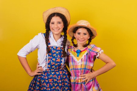 Photo for Sisters and friends, wearing typical clothes for the Festa Junina. hugged with their hands on their hips. For the Arraia party - Royalty Free Image