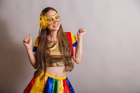 Foto de Hermosa brasileña, mujer caucásica, vistiendo frevo, ropa de carnaval, usando una máscara. bailando. - Imagen libre de derechos
