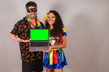 Téléchargez les photos : Couple brésilien, avec des vêtements de carnaval. de tenir un carnet, programmation, web. - en image libre de droit