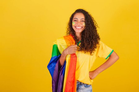 Photo for Young black Brazilian woman, soccer fan. with LGBT flag, Fight against prejudice. - Royalty Free Image