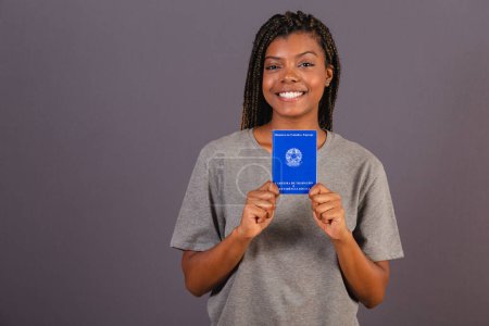Photo for Young afro brazilian woman holding work card and social security. Official document, Human resources, labor market. - Royalty Free Image