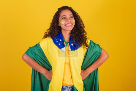 Photo for Young black Brazilian woman, soccer fan. wearing flag, hands on hips. - Royalty Free Image