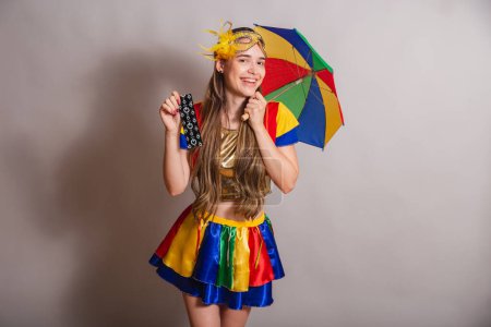 Foto de Hermosa brasileña, mujer caucásica, vistiendo frevo, ropa de carnaval, usando una máscara. sosteniendo condón. Prevención. - Imagen libre de derechos