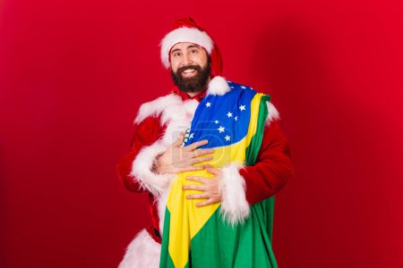 Photo for Brazilian santa claus young caucasian man. with brazil flag. - Royalty Free Image