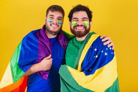 Téléchargez les photos : Couple d'hommes, brésiliens, fans de football brésiliens, portant le drapeau LGBT - en image libre de droit