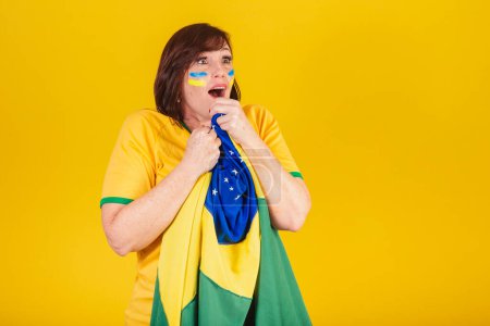 Photo for Red-haired woman, Brazilian soccer fan. fluttering with the flag of Brazil, surprised. - Royalty Free Image