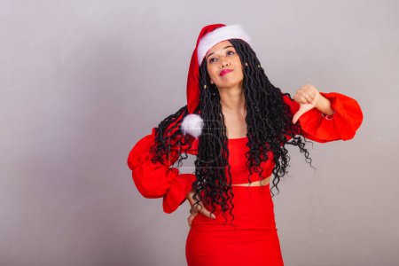 Photo for Brazilian black woman wearing christmas clothes, merry christmas, smiling, dislike sign with hands. - Royalty Free Image