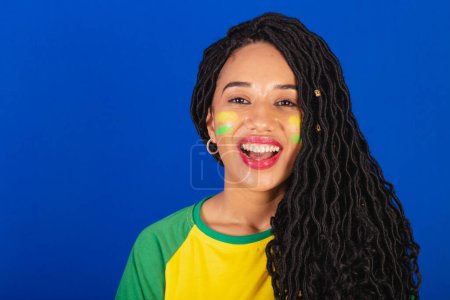 Téléchargez les photos : Jeune Brésilienne noire, fan de foot. photo en gros plan des dents souriantes. - en image libre de droit