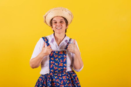 Photo for Mature woman dressed in typical Festa Junina clothes. Thumb up, approval, affirmative. confirmation. - Royalty Free Image