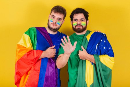 Téléchargez les photos : Couple d'hommes, brésiliens, fans de football brésiliens, portant le drapeau LGBT - en image libre de droit