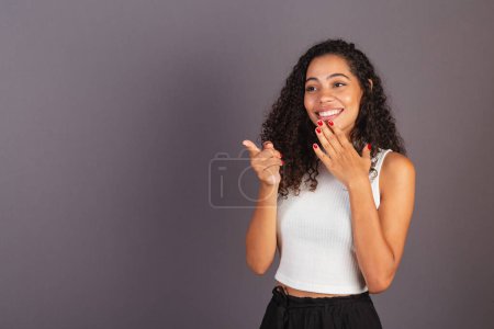 Photo for Young black Brazilian woman, seeing something far to the left. advertising photo. - Royalty Free Image