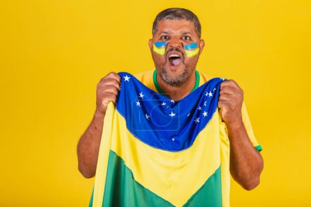 Photo for Brazilian black man, soccer fan from Brazil. waving the brazil flag, celebrating and cheering. - Royalty Free Image