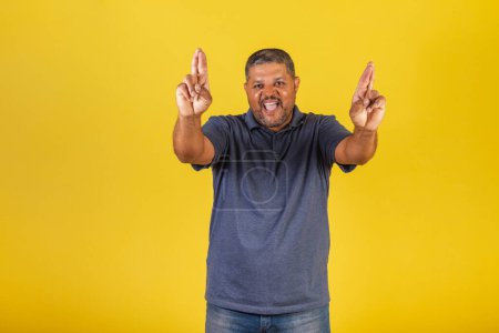 Photo for Brazilian black man, adult smiling, fingers crossed, wishing, sign of luck. - Royalty Free Image