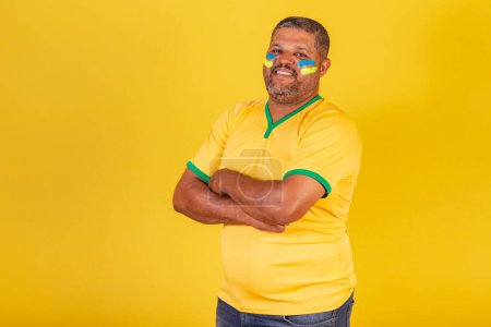 Foto de Hombre negro brasileño, fanático del fútbol de Brasil. brazos cruzados - Imagen libre de derechos