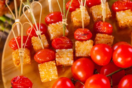 Foto de Comidas buffet gourmet. Palitos de tomate cherry con cubos de tapioca fritos con queso. - Imagen libre de derechos