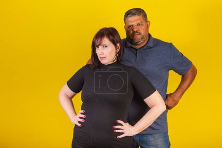 Photo for Brazilian couple, Caucasian woman and black man, hugging, hands on hips. - Royalty Free Image