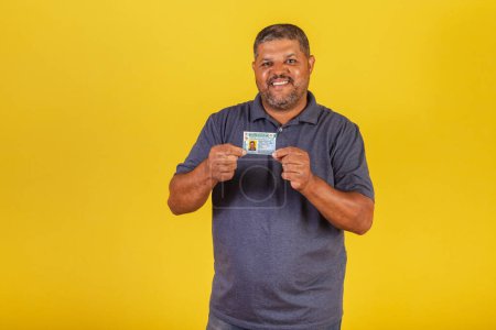 Téléchargez les photos : Homme noir brésilien, adulte avec permis de conduire, document brésilien. - en image libre de droit