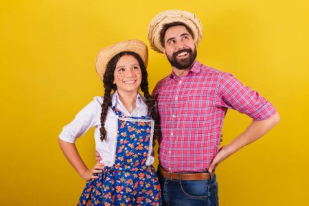 Photo for Father and daughter wearing typical clothes for Festa Junina. with hand on waist. For the Arraia party - Royalty Free Image