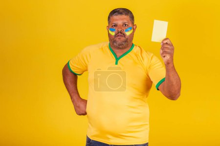 Téléchargez les photos : Homme noir brésilien, fan de football brésilien. montrant le carton jaune. manque - en image libre de droit