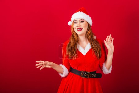 Foto de Hermosa brasileña pelirroja, vestida con ropa de Navidad, Santa Claus. expresión de sorpresa. - Imagen libre de derechos
