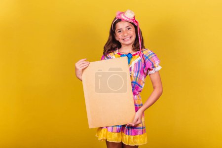 Photo for Brazilian, caucasian, child, festa junina clothes, holding sign for text, advertisement, advertisement. May, June and July festivities, festa junina celebrations - Royalty Free Image