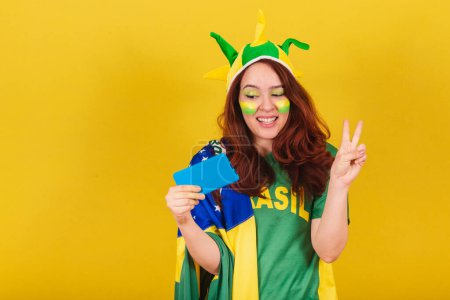 Photo for Caucasian redhead woman brazil soccer fan posing for selfie, self portrait with cellphone, smartphone, online. - Royalty Free Image