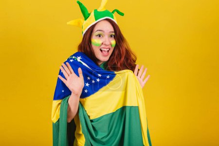 Photo for Caucasian woman, redhead, soccer fan from Brazil, amazed, wow, incredible, unbelievable. - Royalty Free Image