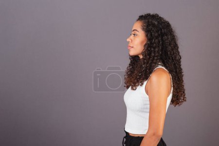 Téléchargez les photos : Jeune femme brésilienne noire, de profil latéral regardant à gauche. - en image libre de droit