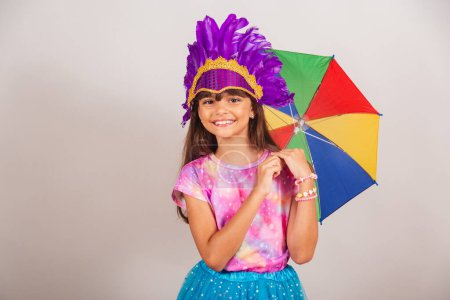 Foto de Hermosa chica brasileña, niña, vestida para el carnaval en Brasil. sonriendo con paraguas frevo. - Imagen libre de derechos