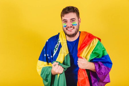 Foto de Hombre caucásico brasileño, fanático del fútbol de Brasil, portador de bandera LGBT, concepto de igualdad de género, diversidad. Sexualidad - Imagen libre de derechos