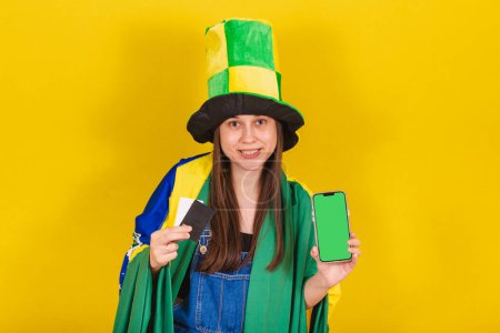 Photo for Woman, brazil soccer fan, holding credit card and cellphone, mobile apps, online shopping, shopping by cellphone. - Royalty Free Image
