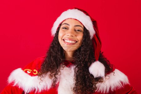 Téléchargez les photos : Belle femme noire brésilienne, habillée en Père Noël claus, vêtements de Noël. souriant, photo en gros plan, regardant la caméra. - en image libre de droit