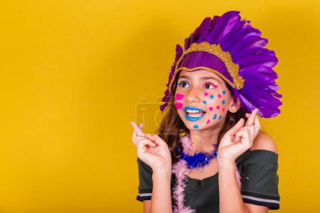 Photo for Caucasian, brazilian child dressed for carnival. Fingers crossed, wishing, twisting, wanting. - Royalty Free Image