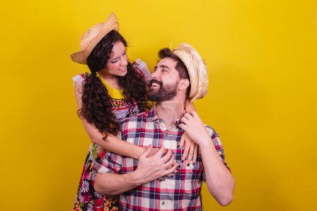 Photo for Beautiful couple dressed in typical clothes for a Festa Junina. Arraia de Sao Joao. Hugging dating. - Royalty Free Image