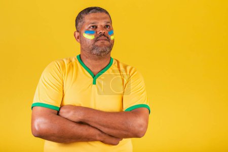 Téléchargez les photos : Homme noir brésilien, fan de football brésilien. bras croisés. Optimiste. pour de vrai. - en image libre de droit